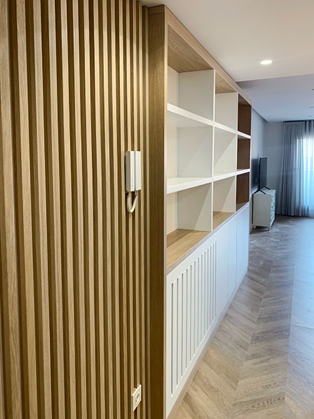 Panelado de listones de haya integrado con mueble librería en salón