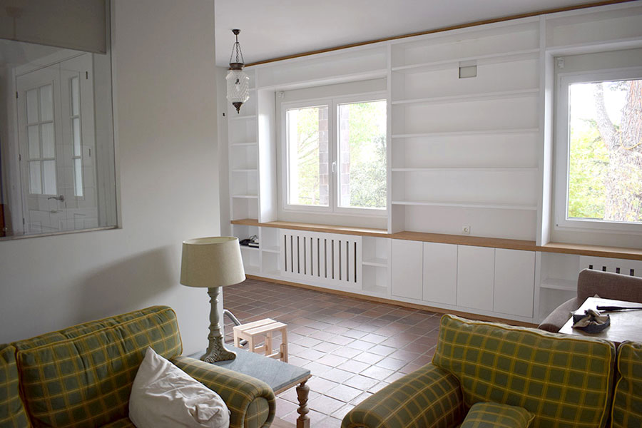 Librería lacada en blanco con puertas, cubre radiadores y repisa de madera