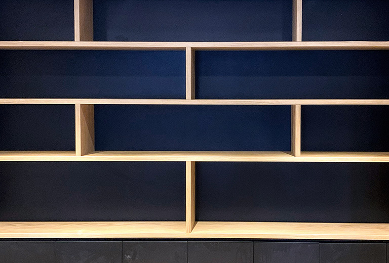 Librería madera trasera azul Librería a medida con baldas en madera y trasera lacada azul