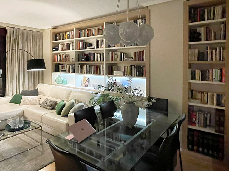 Salón con librería tras el sofá Visión general del salón con una librería a medida para colocar el sofá delante