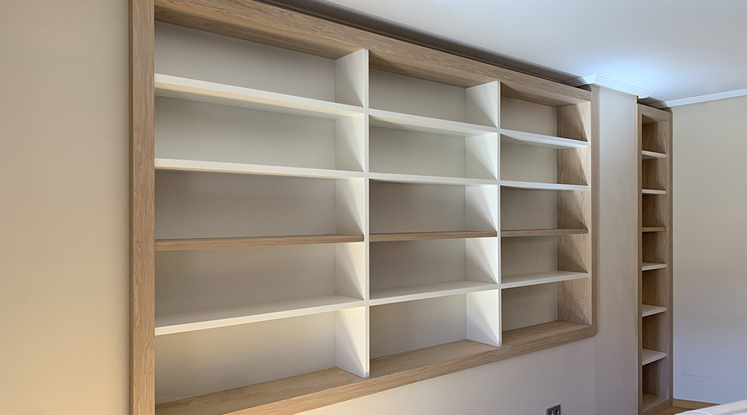 libreria-tras-sofa-blanca-madera Librería mural a medida lacado blanco combinada con madera