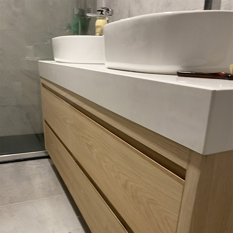 Mueble de baño con dos lavabos porcelánicos sobre encimera