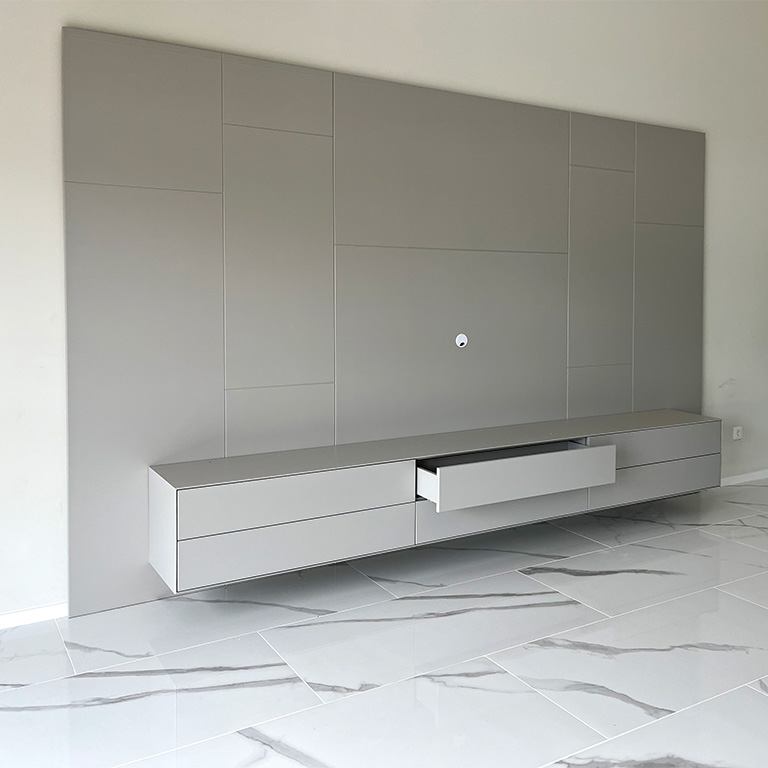 Mueble de salón lacado gris con trasera panelada y cajones