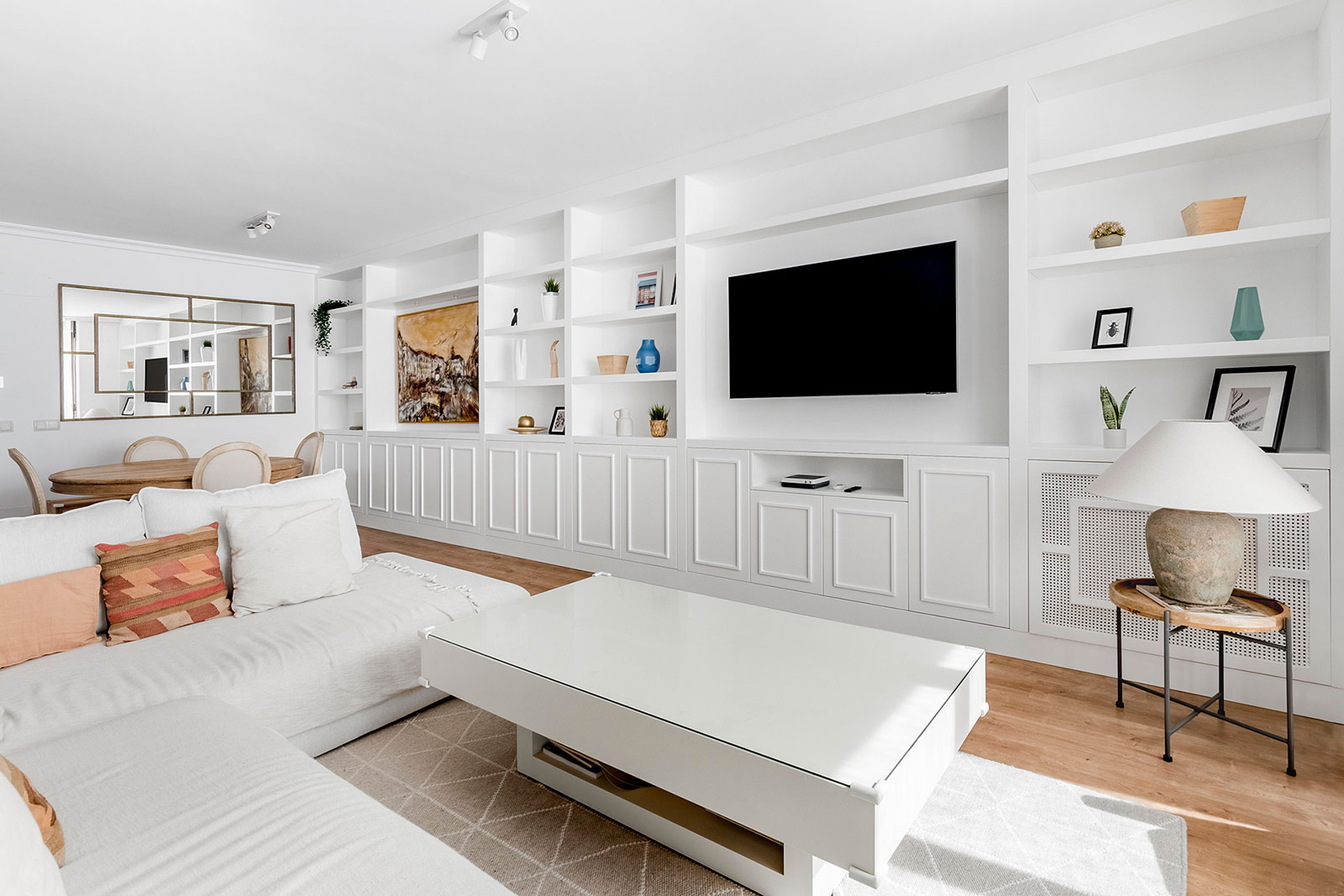 Vista panorámida de salón con zona de estar y muebles a medida lacado blanco
