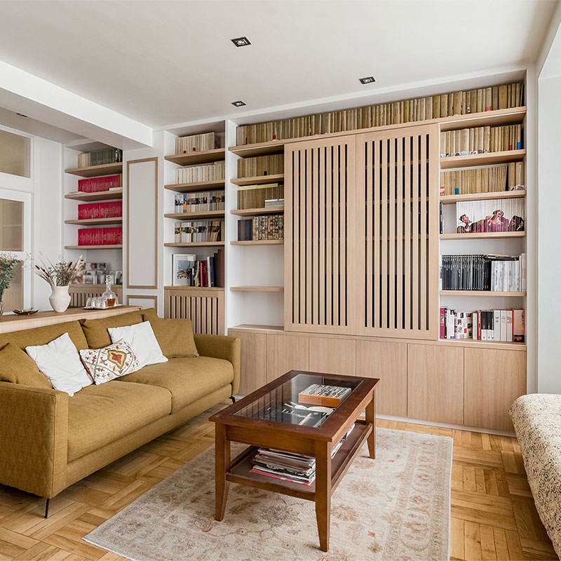 Librería a medida para salón con puertas correderas que ocultan la TV