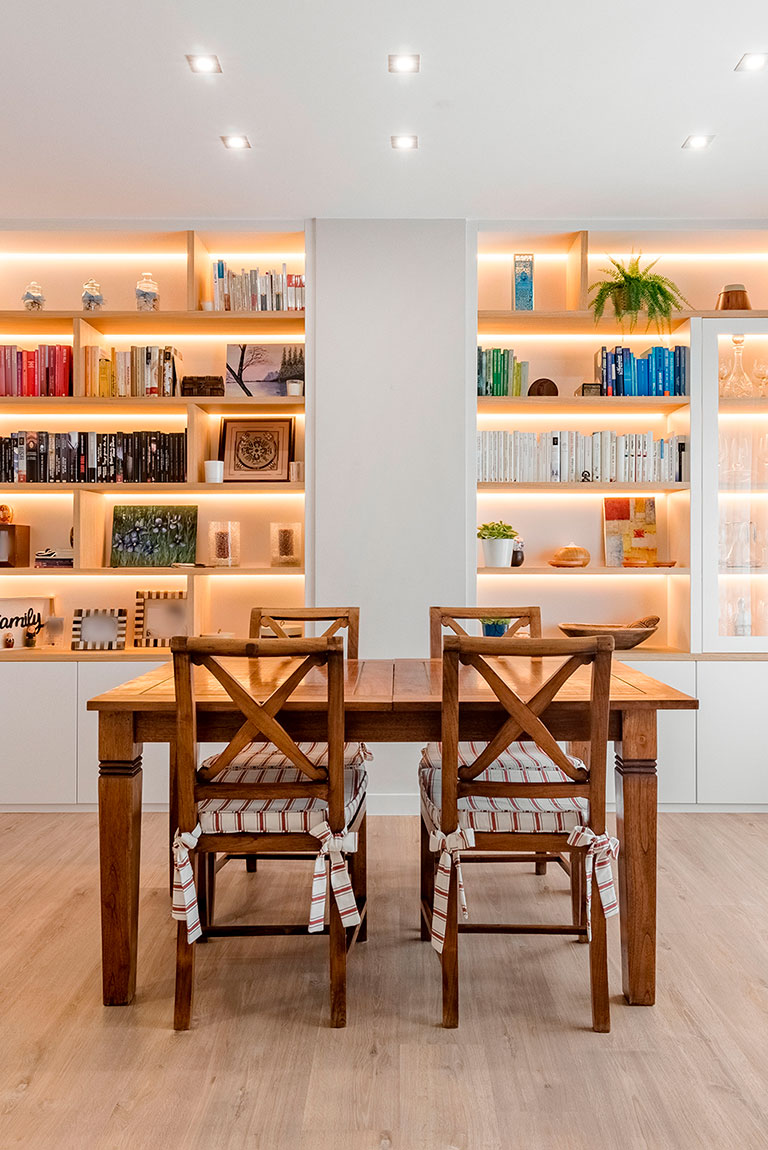Comedor con mesa rústica y librería blanca a medida