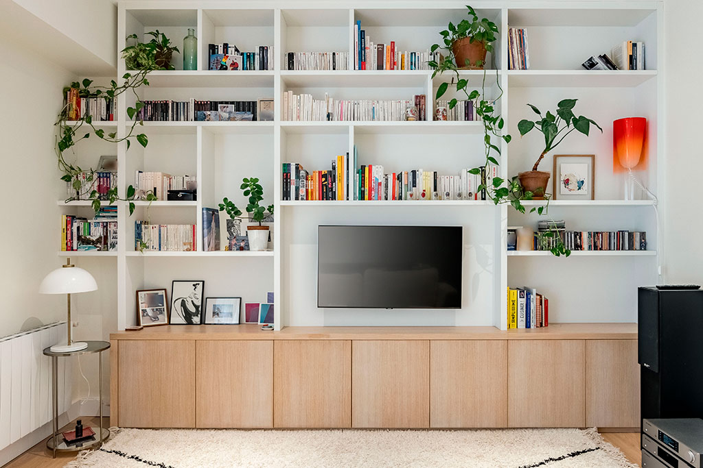 Librería mural para salón con mueble bajo en madera natural