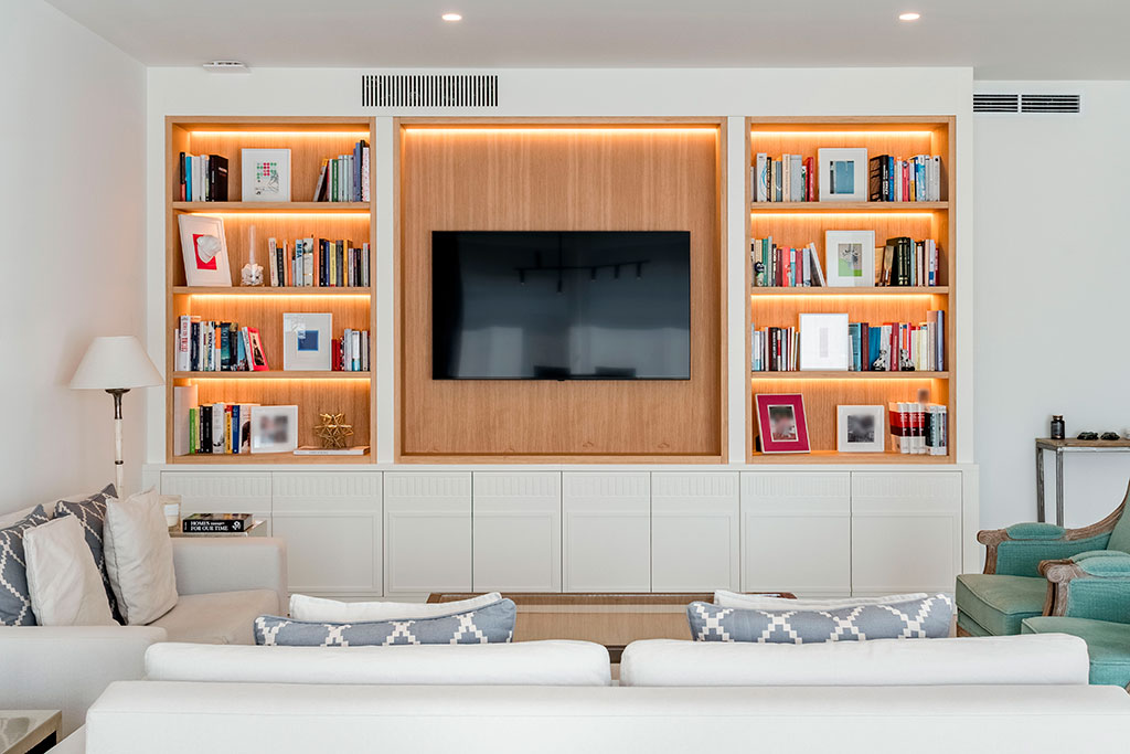 Vista frontal del mueble mural para salón en blanco y madera de nogal con iluminación led