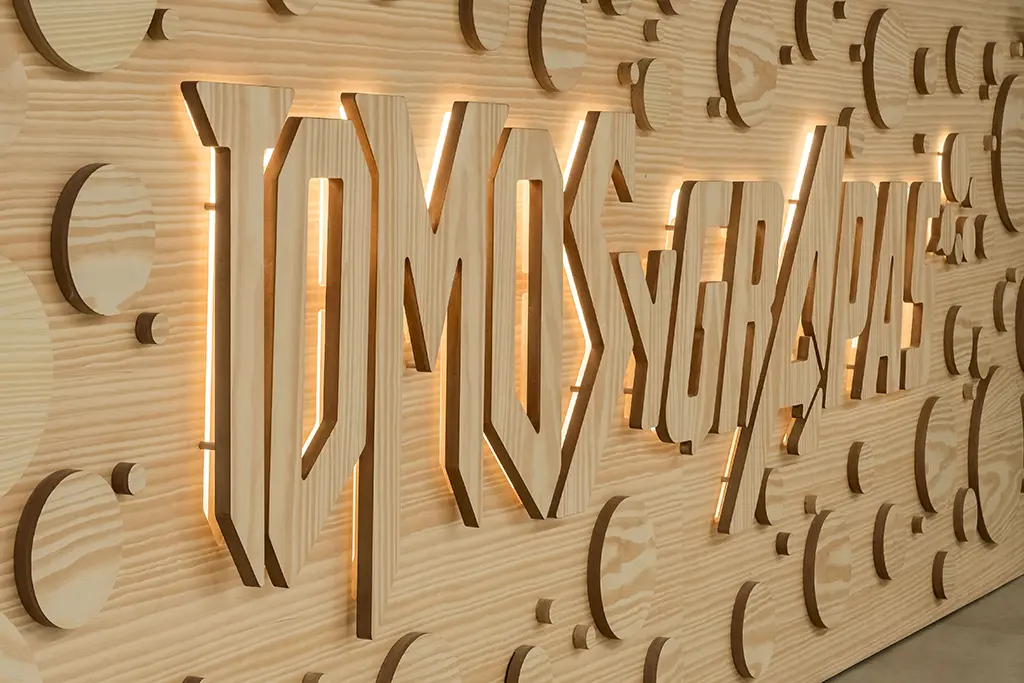 Detalle del mostrador en madera con nombre en relieve TOMOS Y GRAPAS